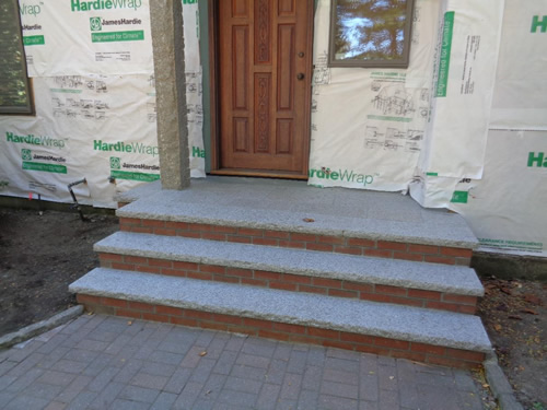 Brick risers and 2" reclaimed granite treads on side entry.